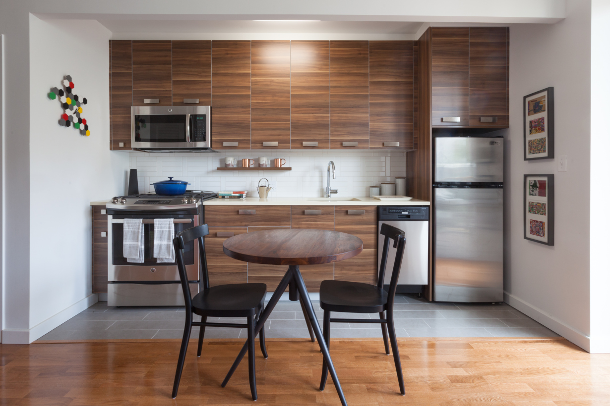 a kitchen with a table chairs refrigerator and microwave