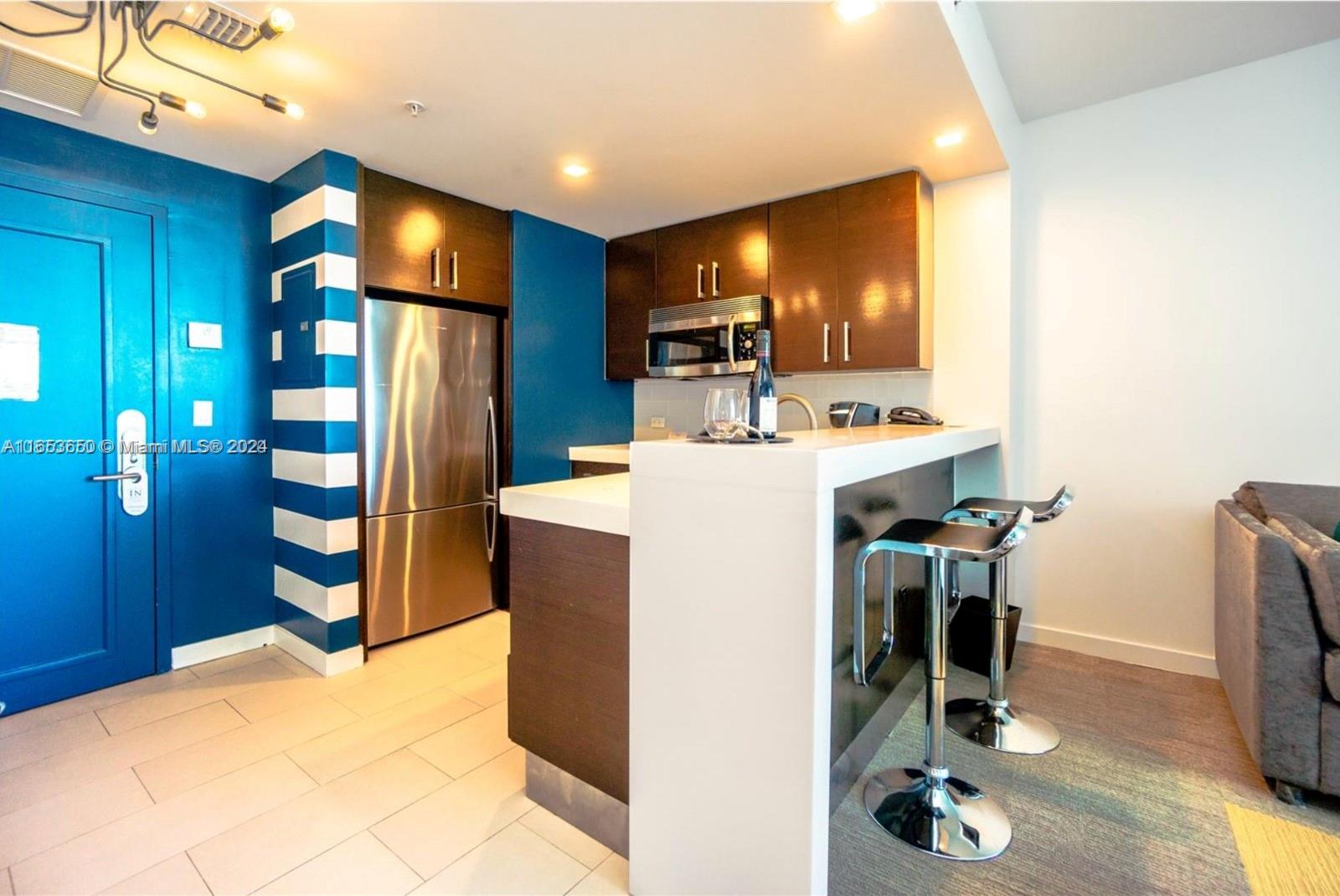 a view of a kitchen with fridge and workspace