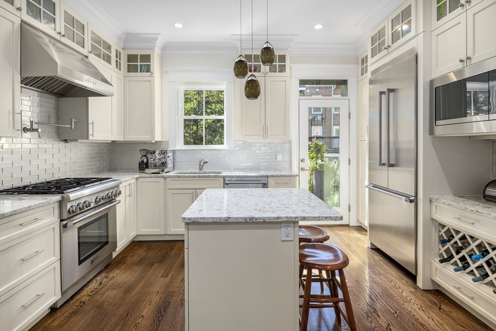 a kitchen with stainless steel appliances granite countertop a sink stove and refrigerator