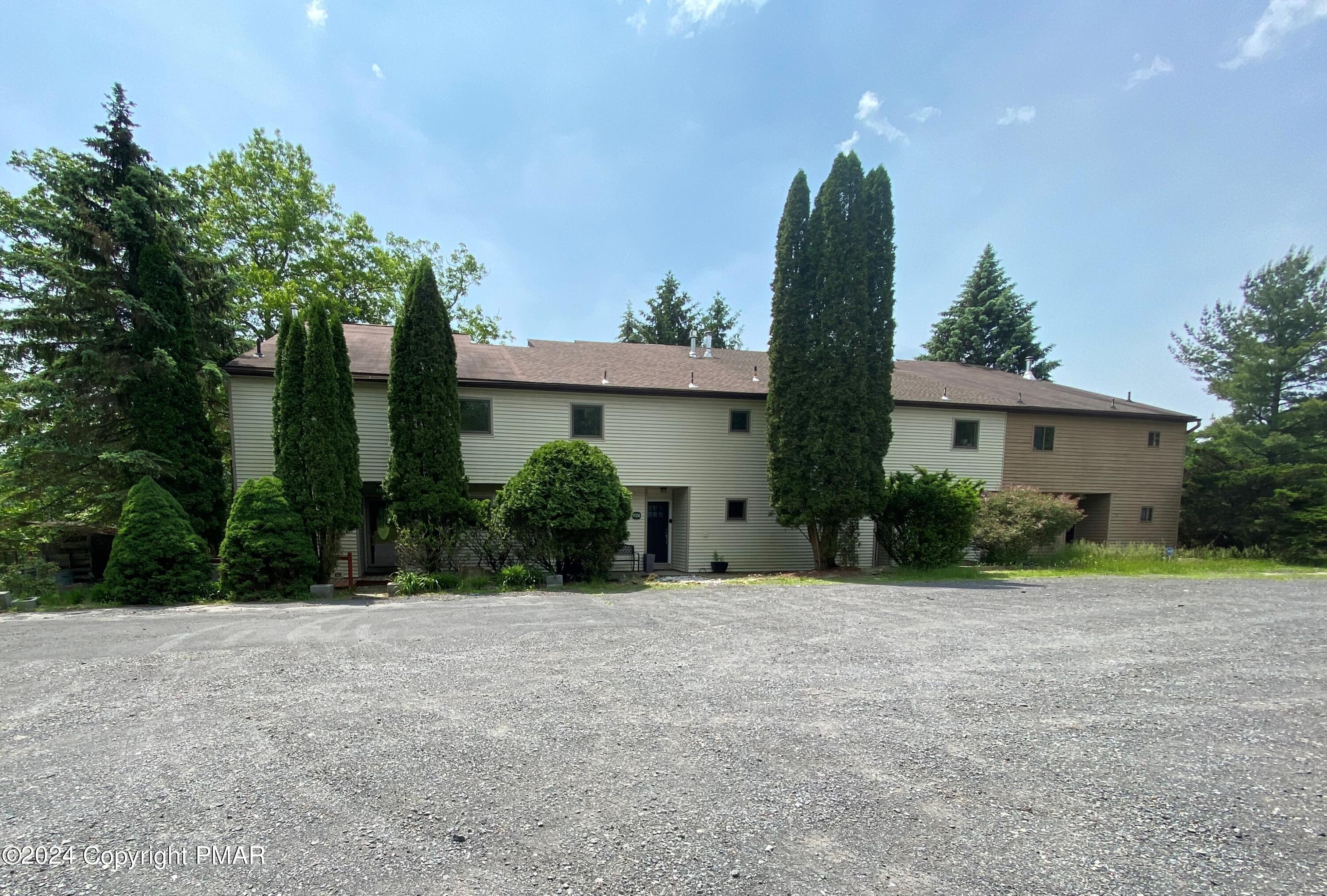 a front view of a house with a yard and potted plants