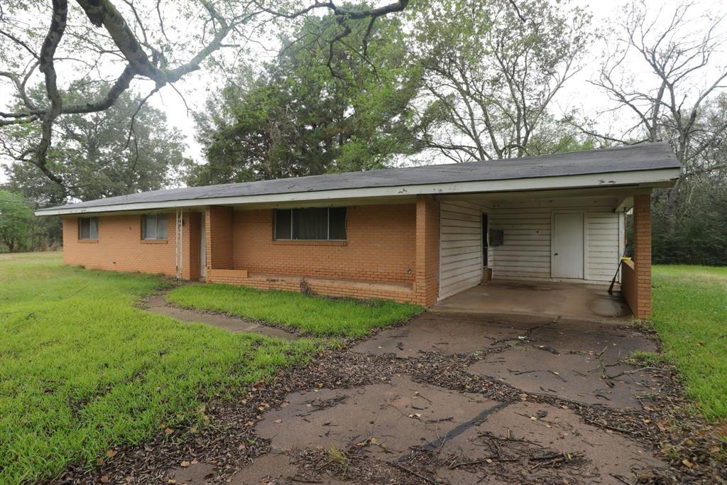 a backyard of a house with large trees and barbeque oven