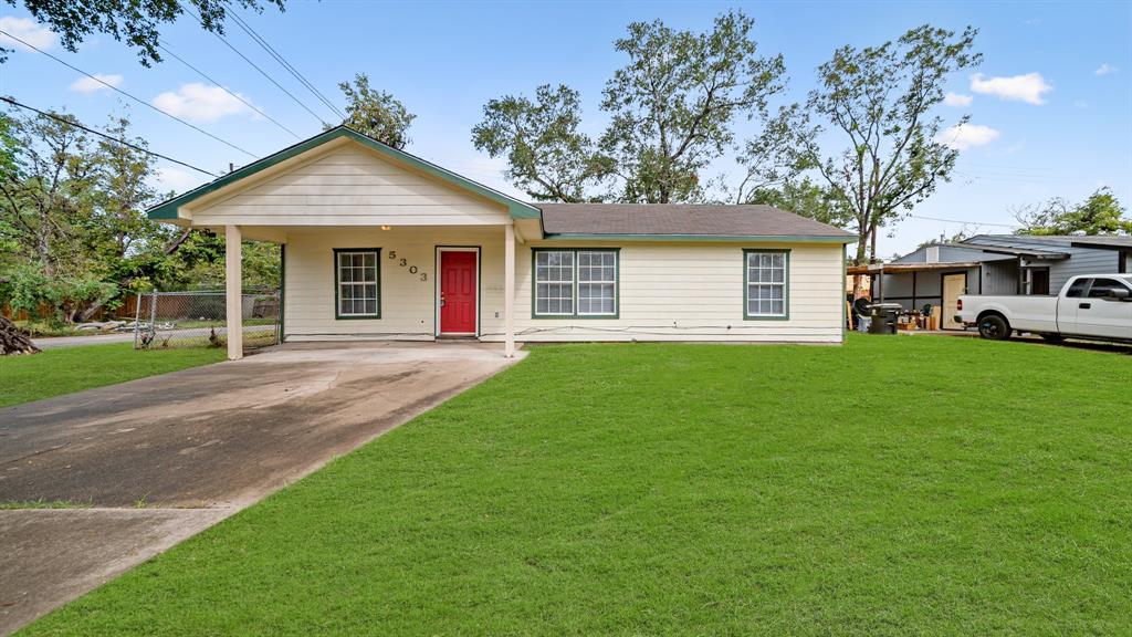 a front view of a house with a yard and trees