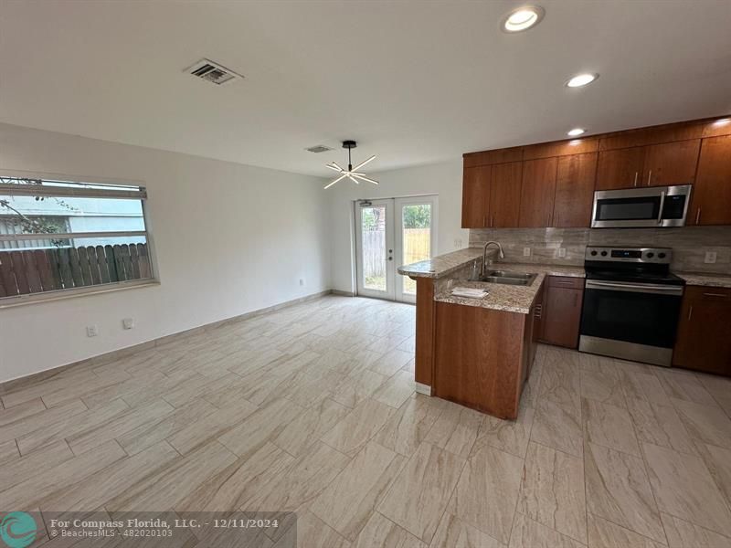 a kitchen with stainless steel appliances granite countertop a stove a sink and a refrigerator