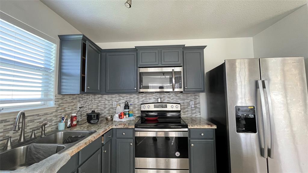 a kitchen with stainless steel appliances a stove a sink and a refrigerator