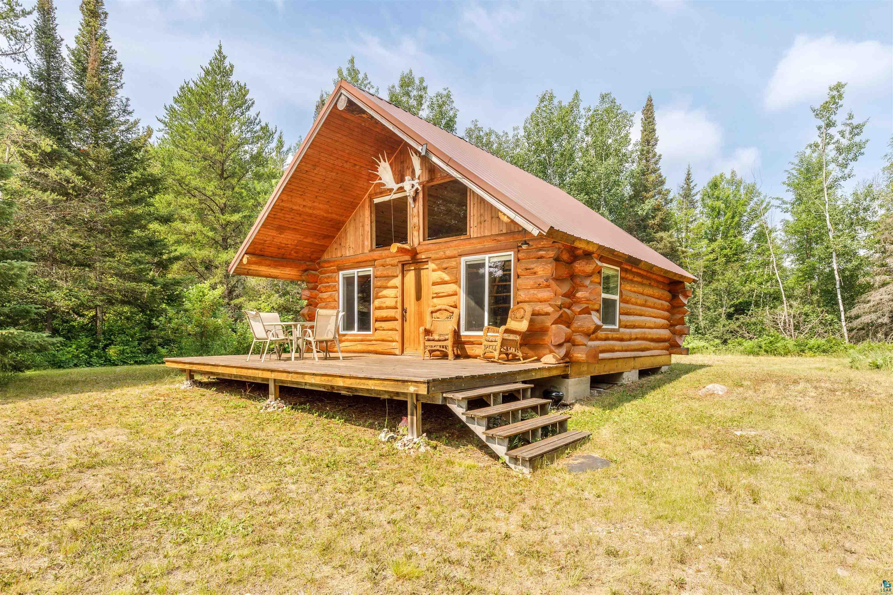 View of front facade featuring a wooden deck and a front lawn