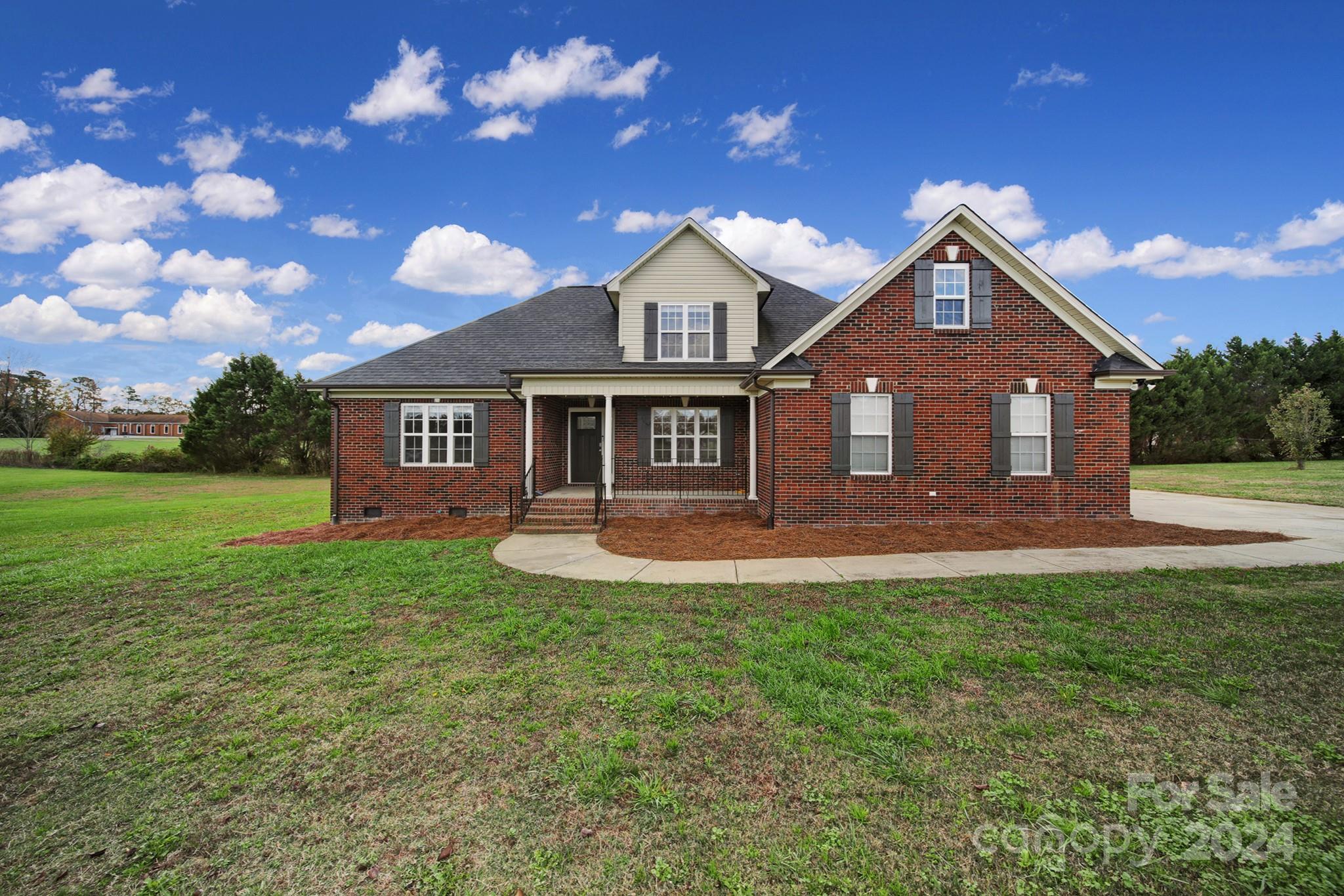 a front view of a house with yard and green space