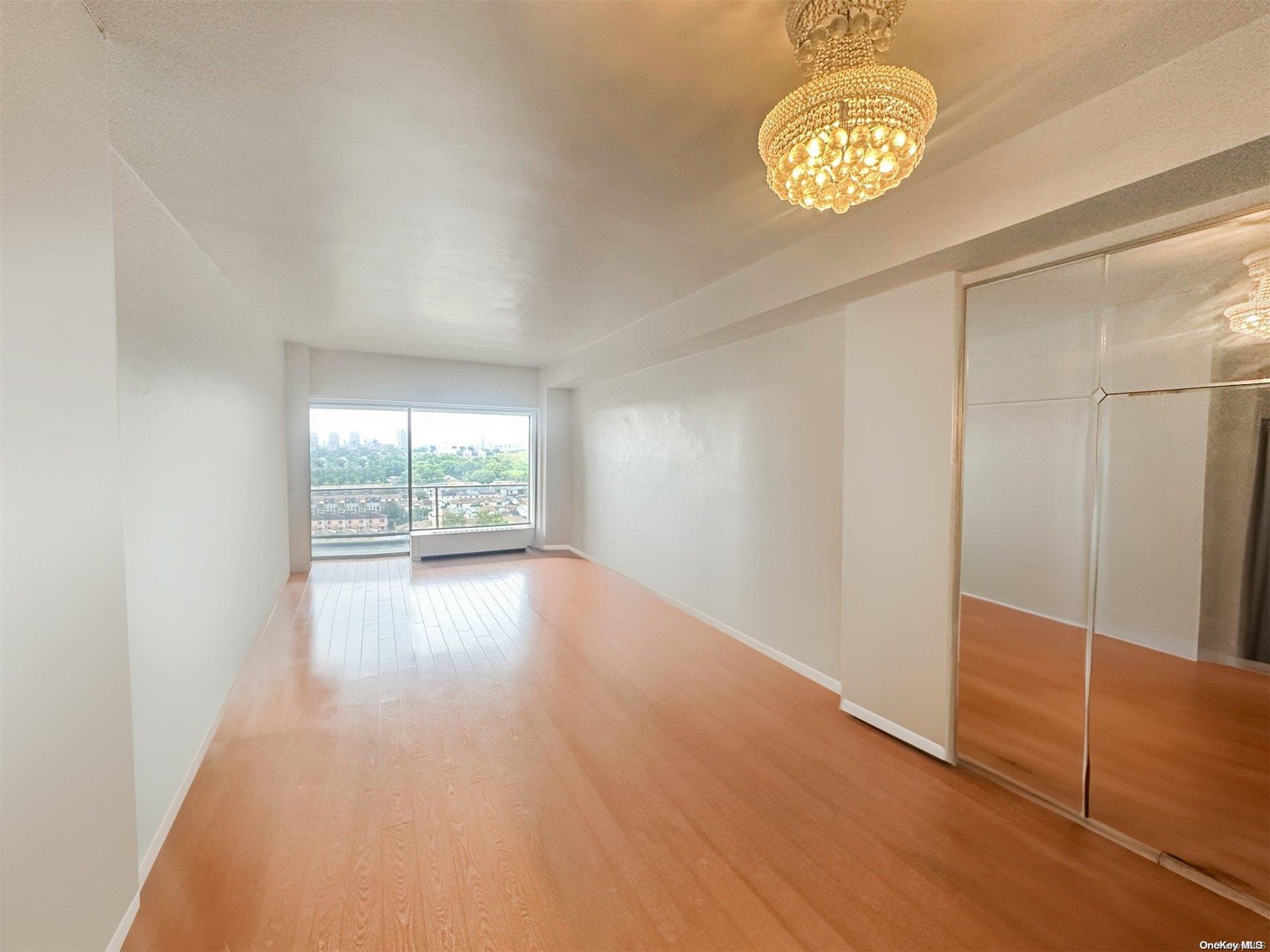 an empty room with wooden floor and door