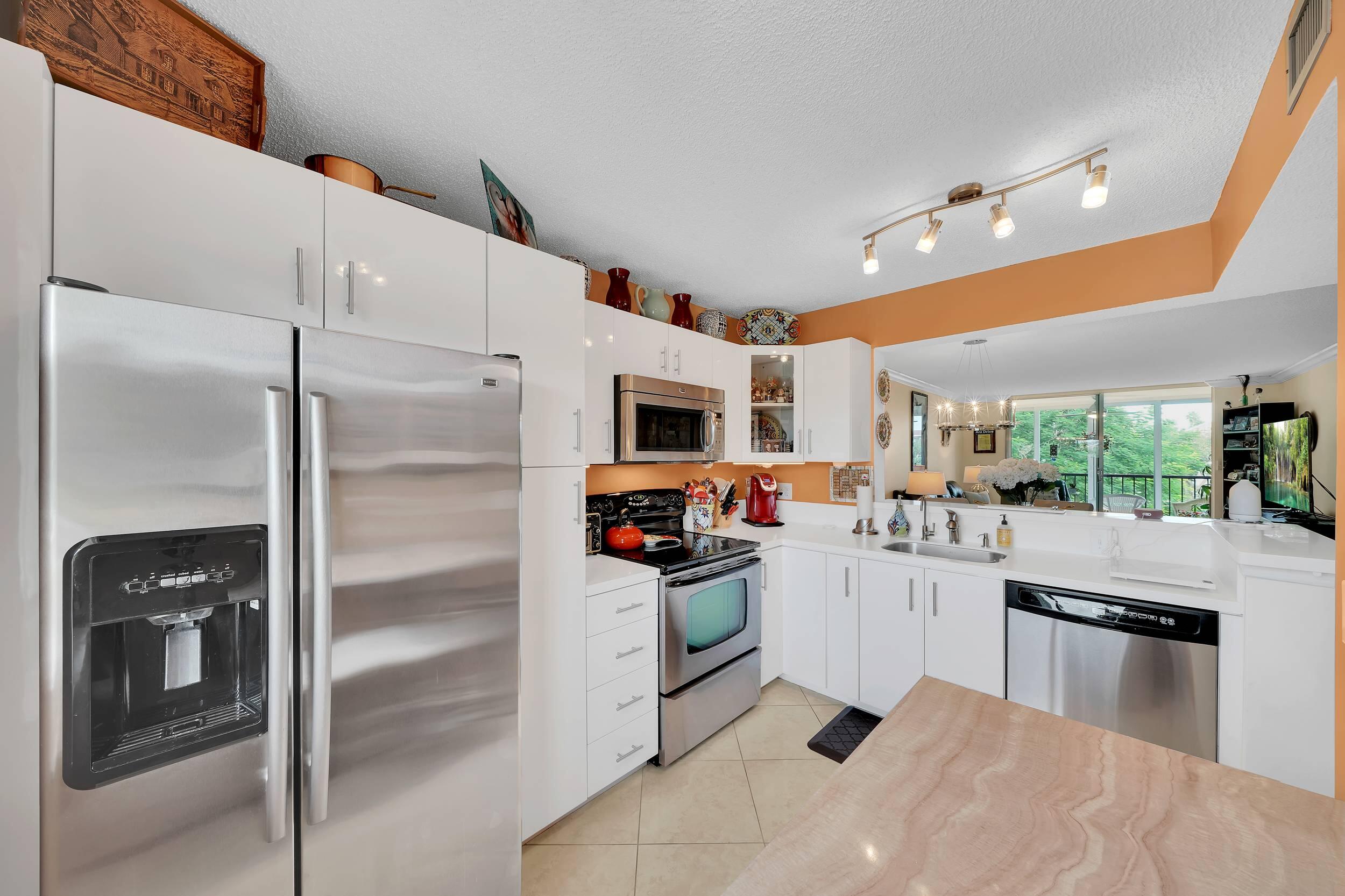 a kitchen with stainless steel appliances granite countertop a refrigerator and a stove