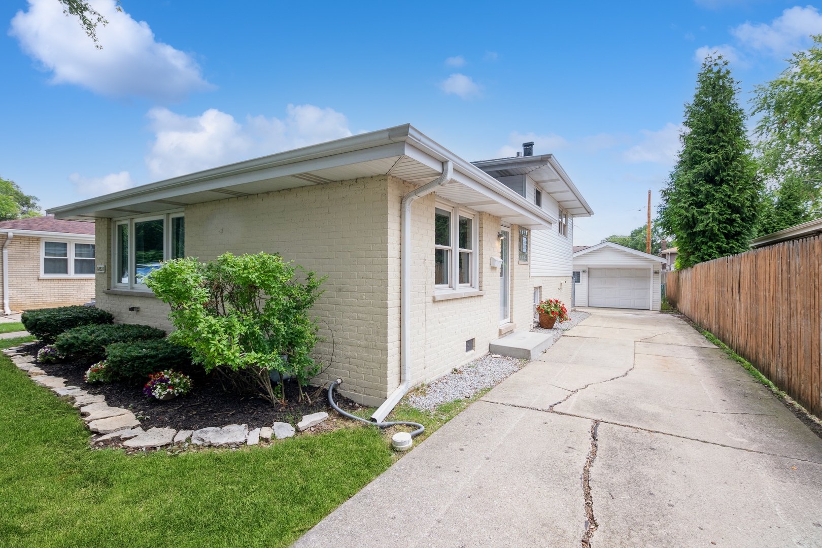 a front view of a house with a yard and potted plants