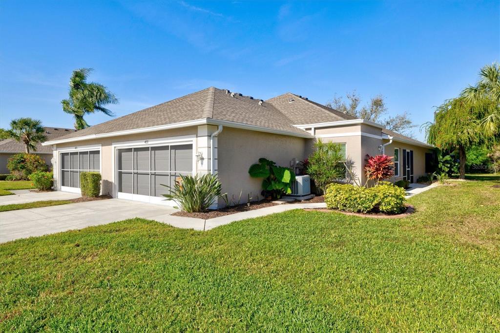 a front view of a house with a yard and potted plants