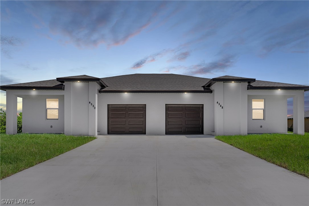 a front view of a house with yard and garage