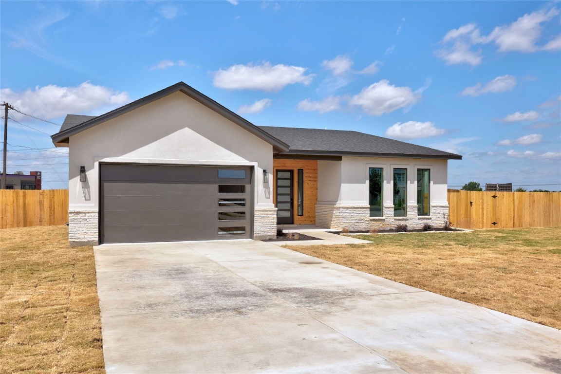 a view of a house with a patio and a yard