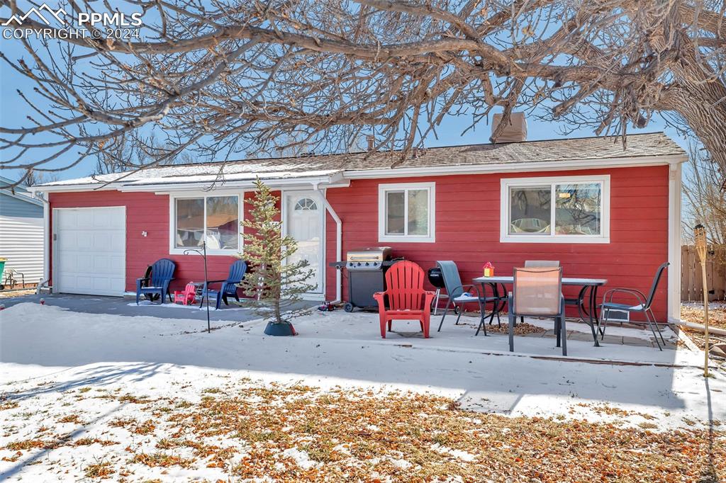 Snow covered front of property featuring a garage