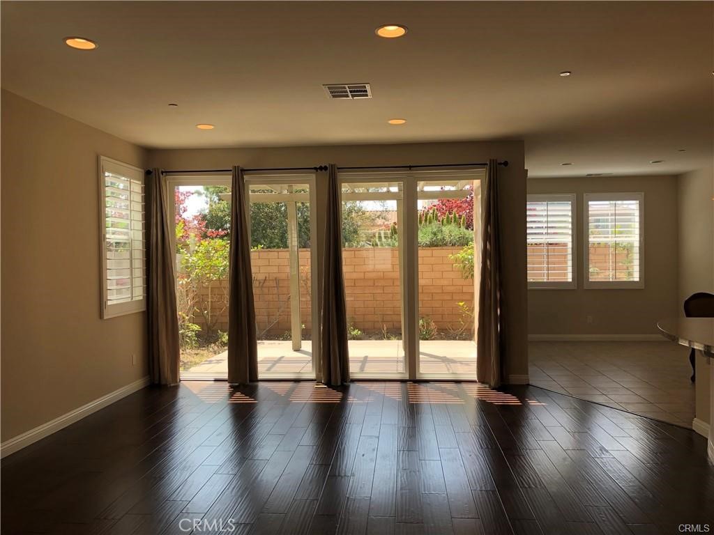 an empty room with large windows and wooden floor