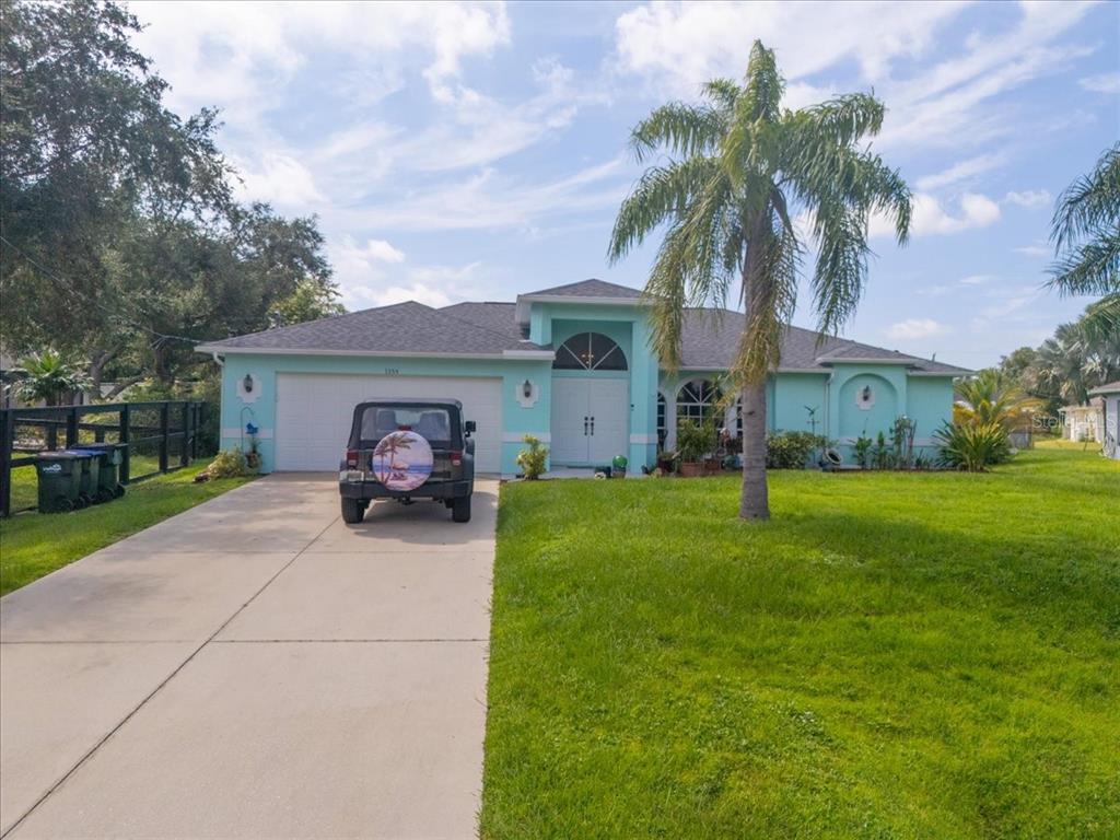 a view of a house with backyard and a tree