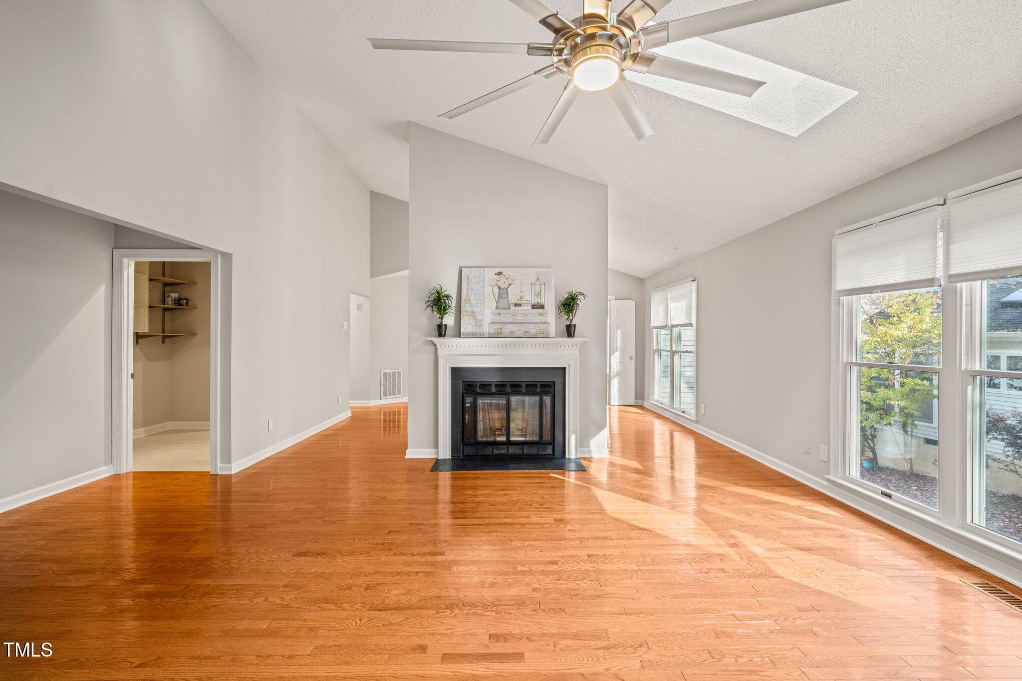 a view of an empty room with a fireplace and a window