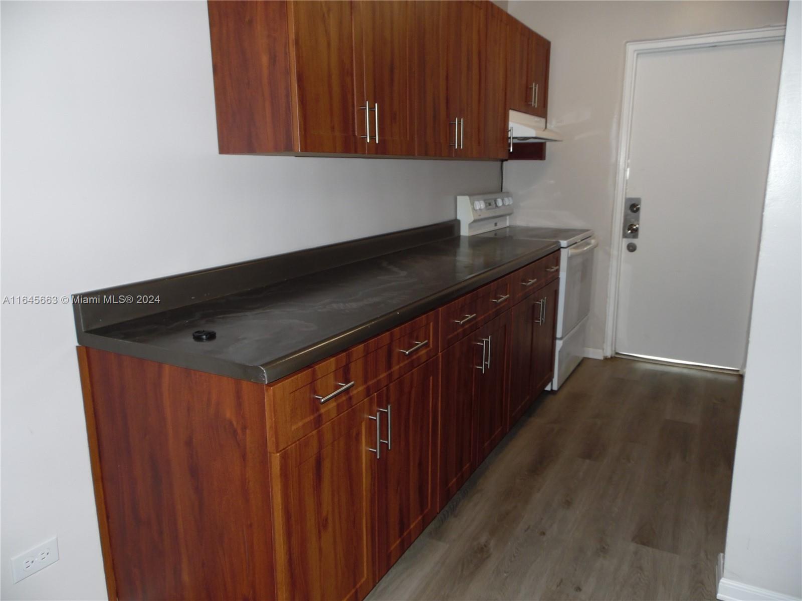 a kitchen with granite countertop a sink and cabinets