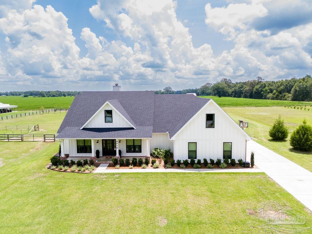 a front view of house with swimming pool and green space