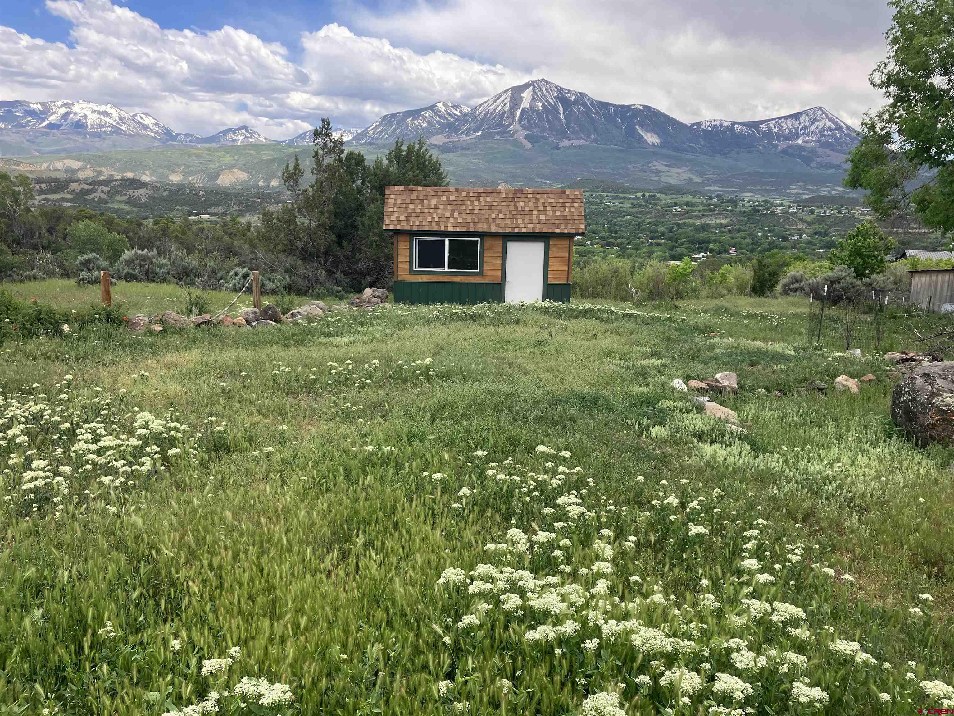 a front view of a house with a yard and mountain