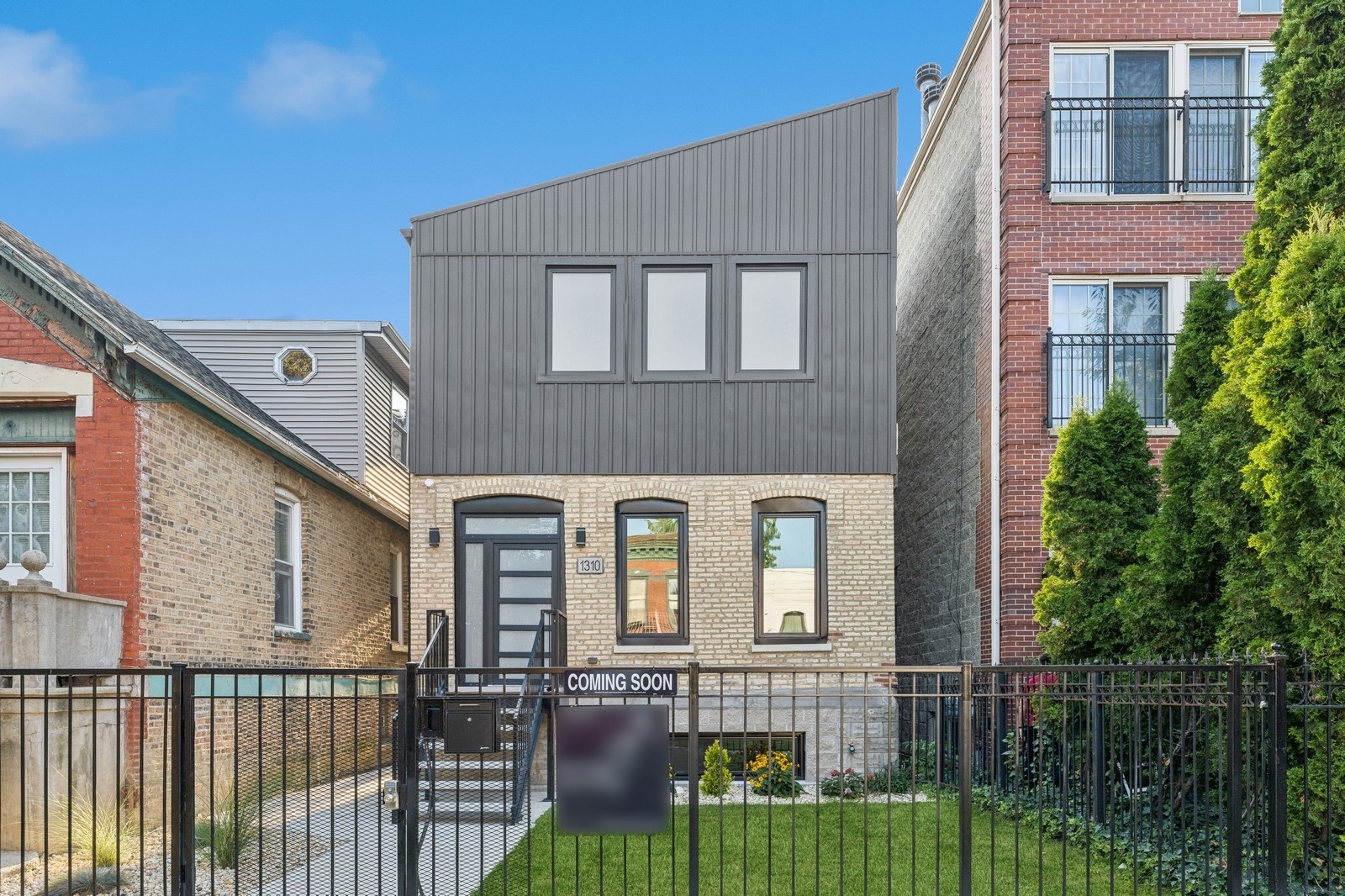 a front view of a house with glass windows and fence