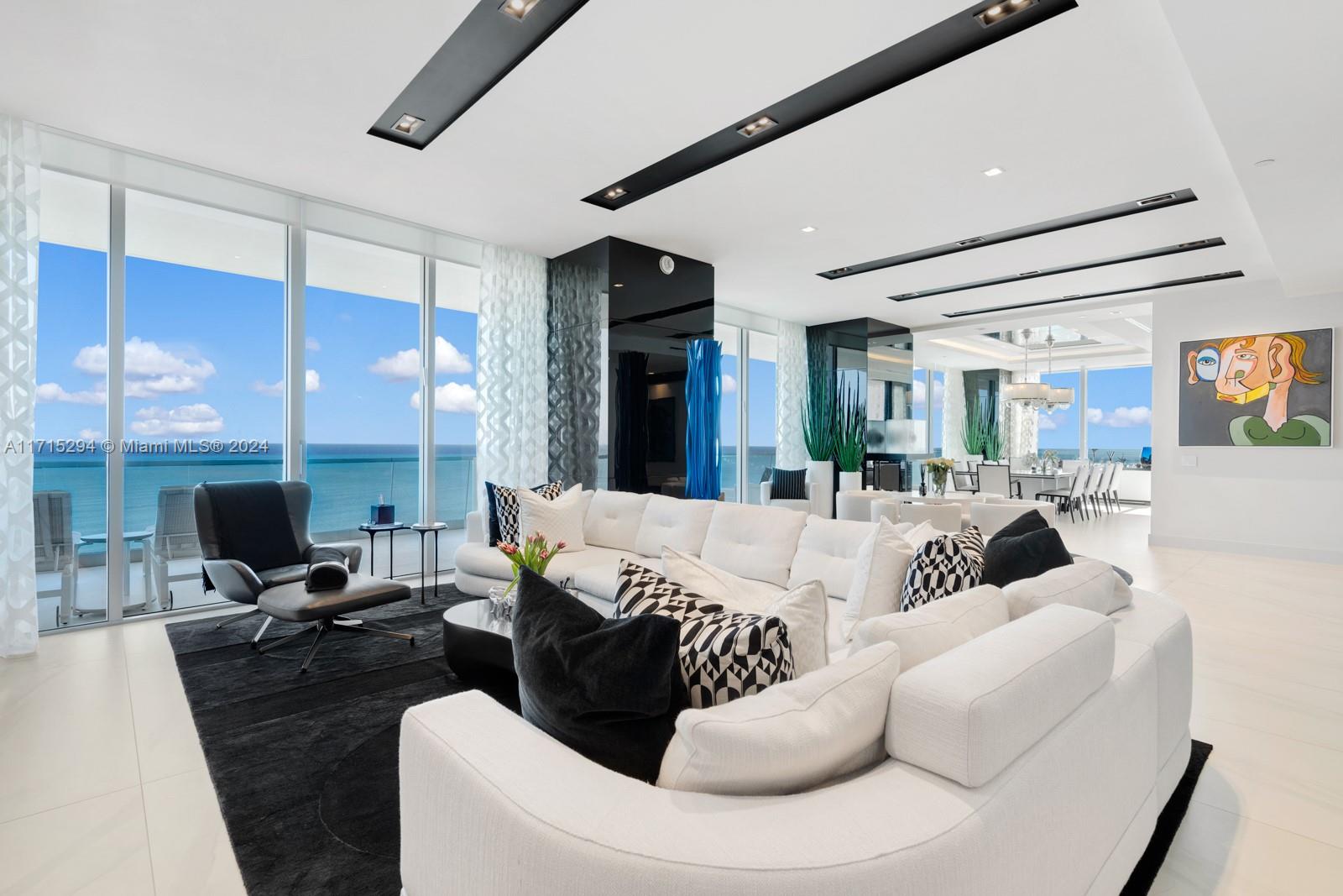 a living room with furniture kitchen view and a large window