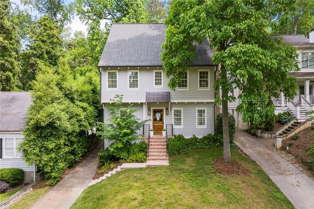 a front view of a house with a yard and trees