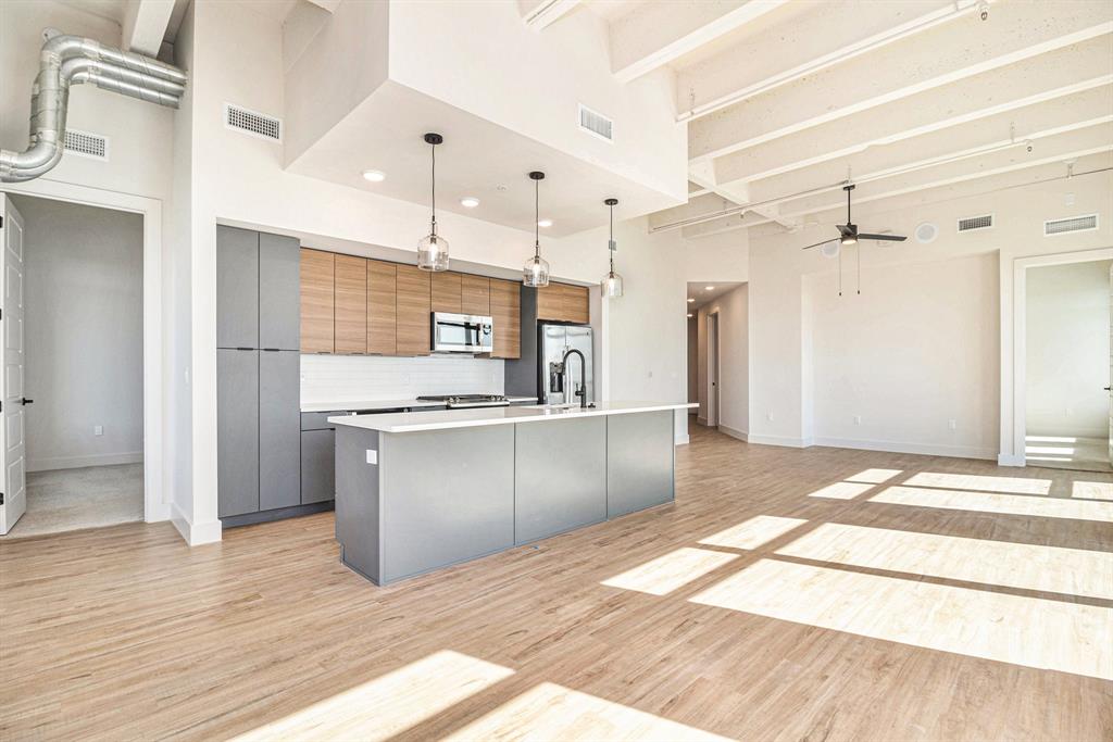 a open kitchen with stainless steel appliances kitchen island granite countertop a refrigerator and a sink