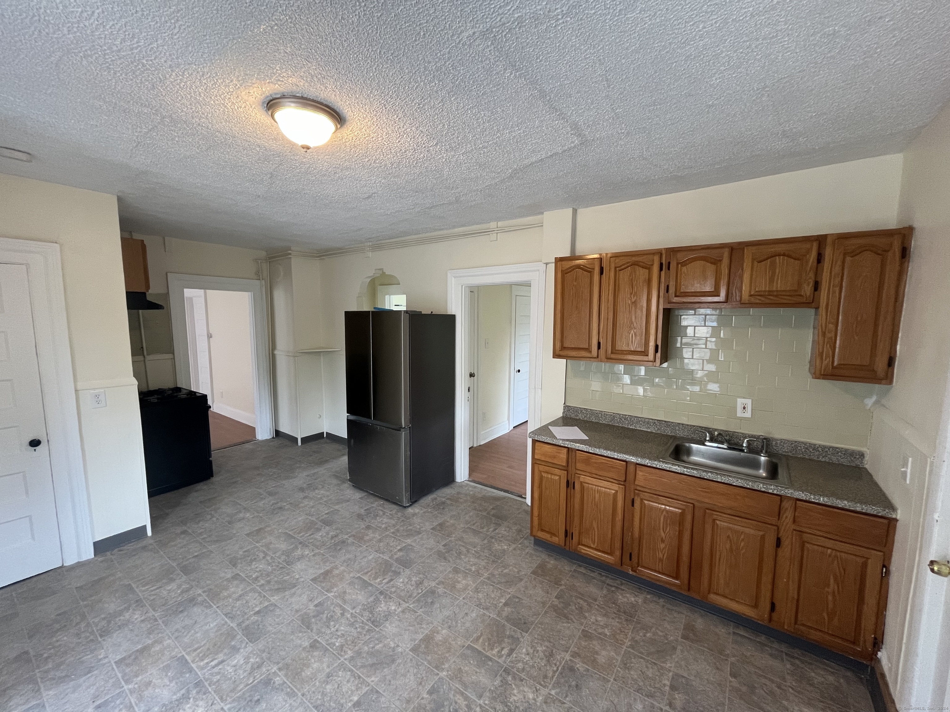 a kitchen with stainless steel appliances granite countertop a refrigerator and a sink