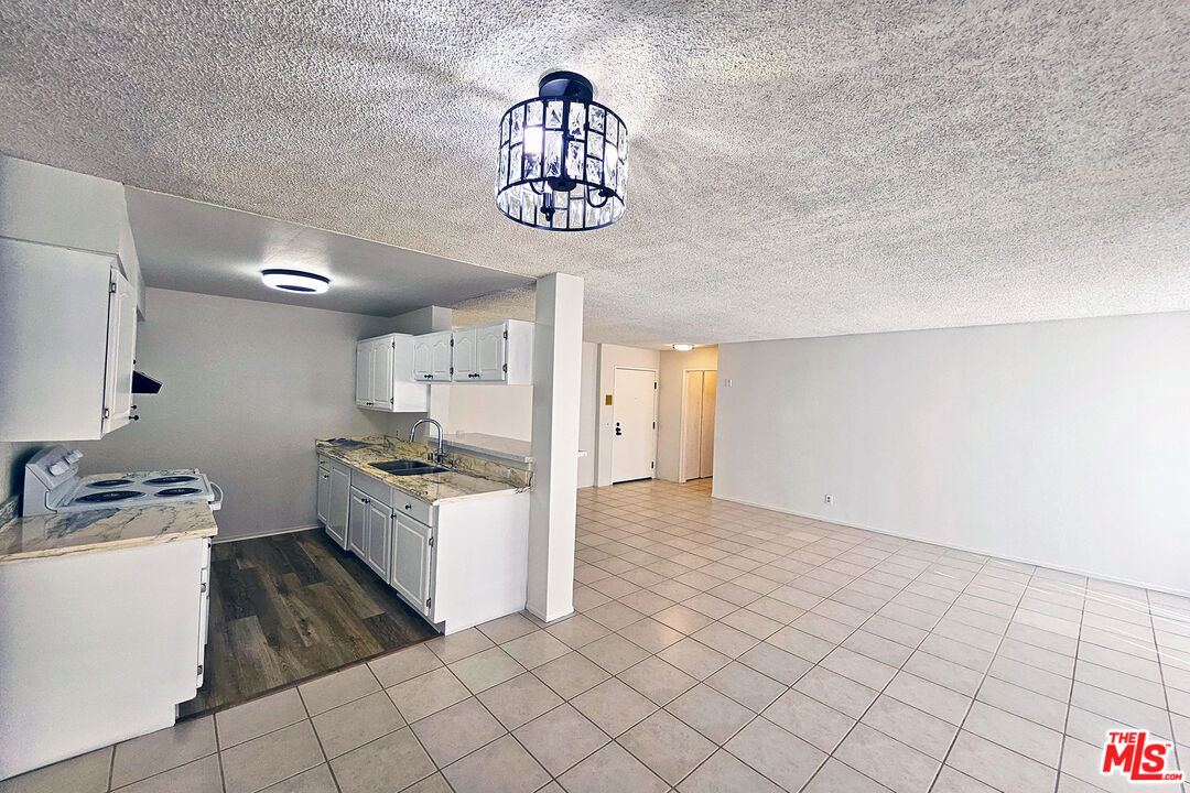 a kitchen with granite countertop white cabinets and white appliances