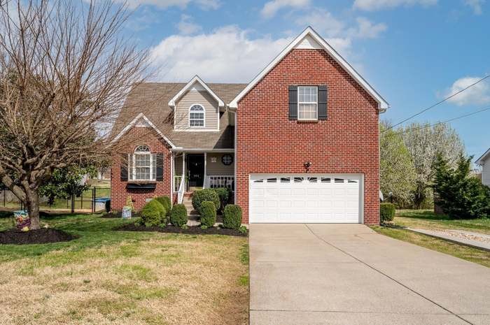 a front view of a house with a yard and garage