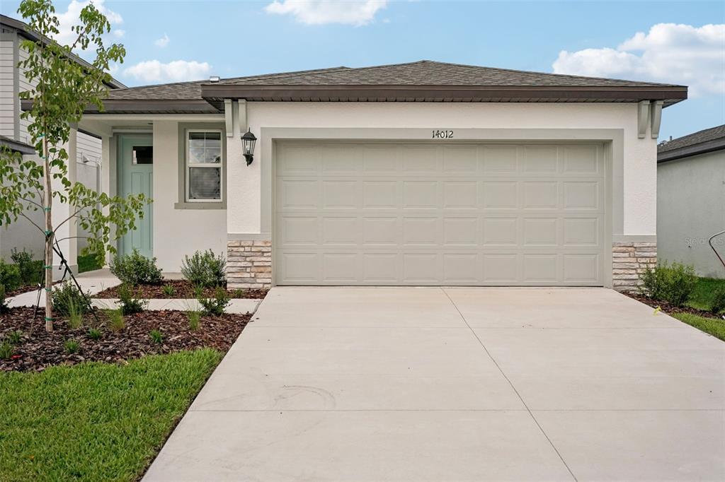 a front view of a house with a yard and garage