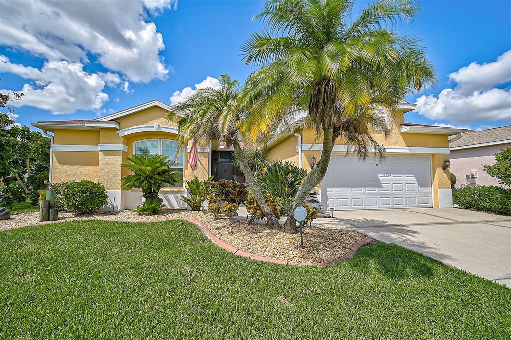 a view of a house with a yard and palm trees