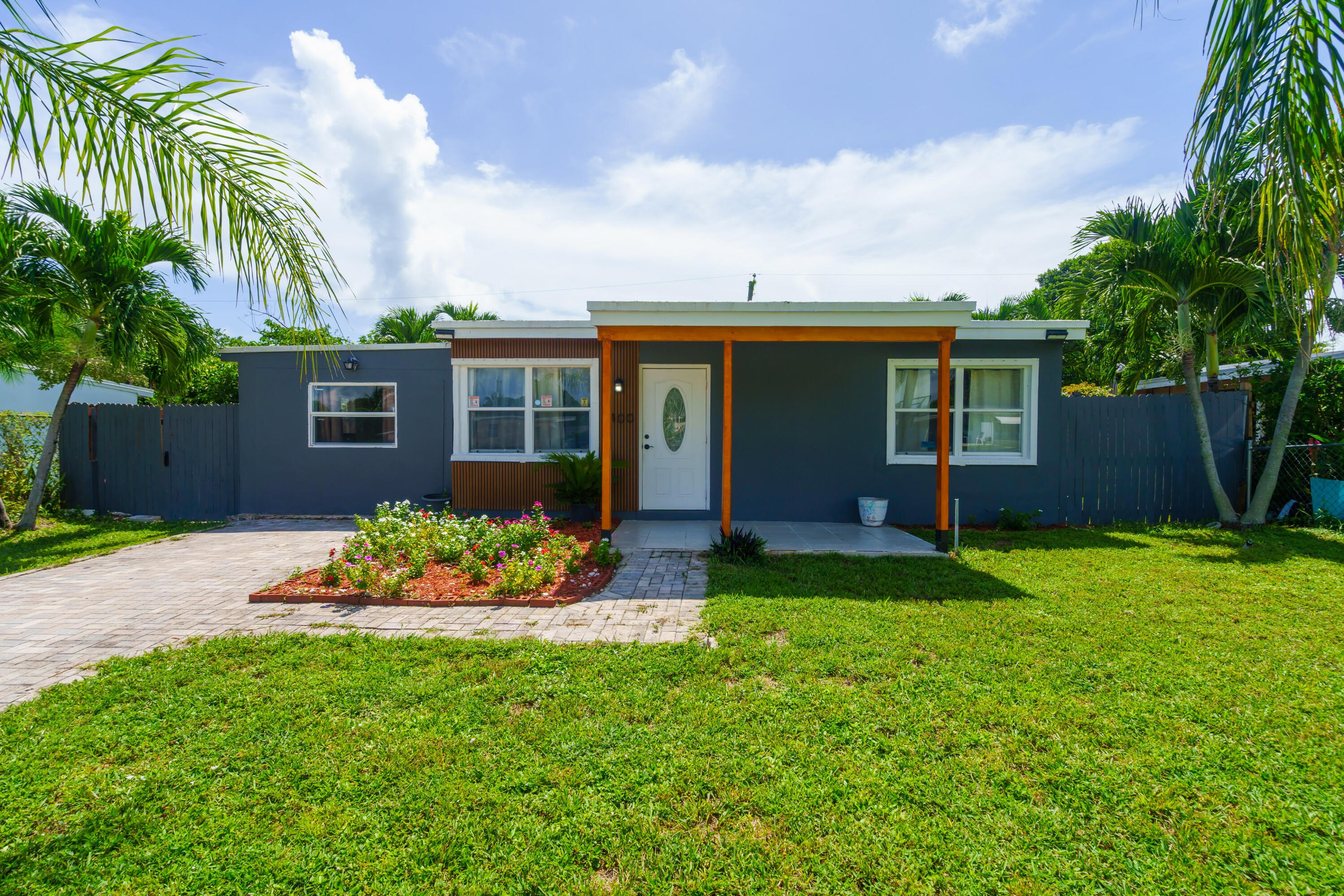 a front view of a house with a garden and yard