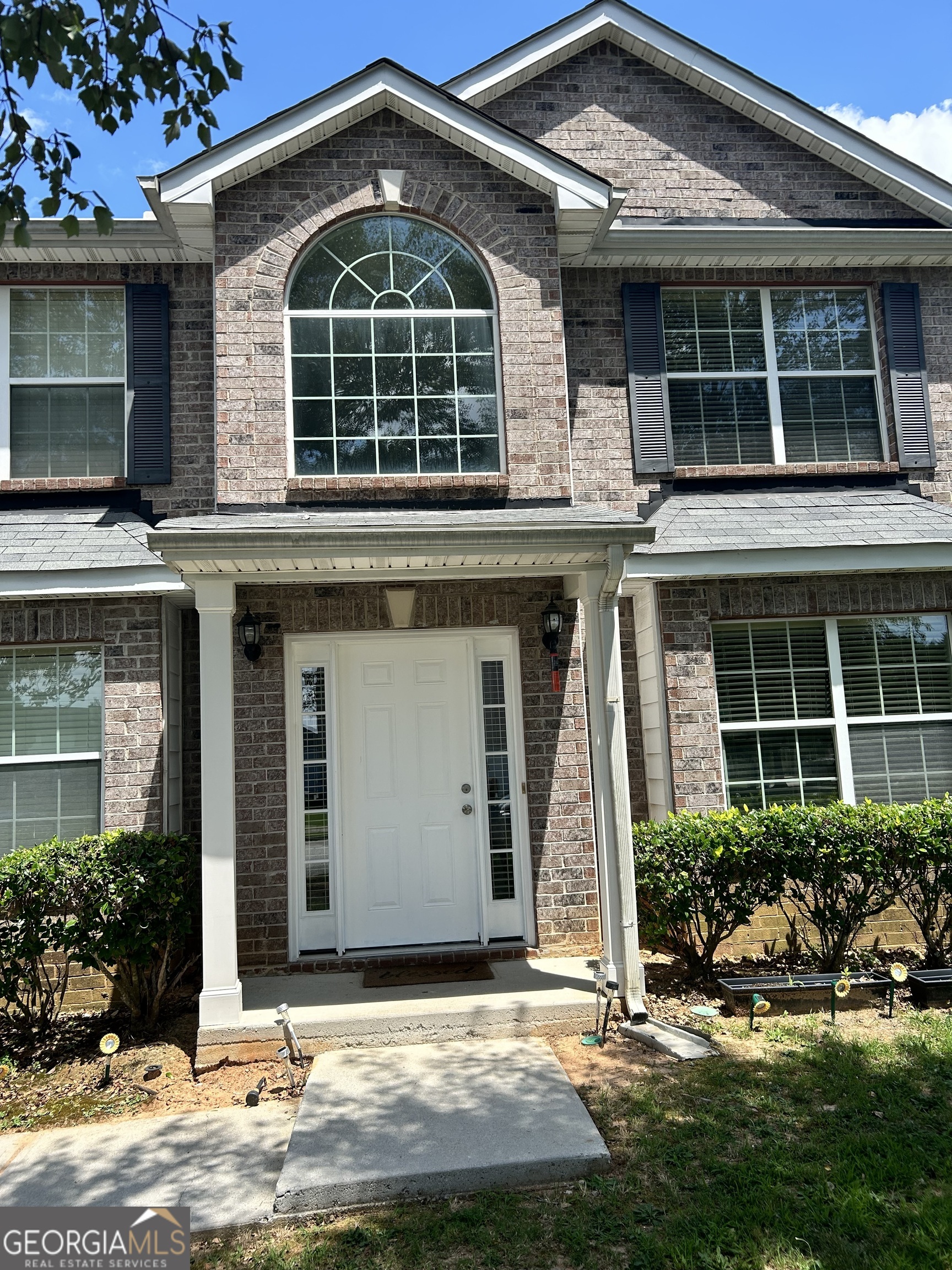 a front view of a house with garden