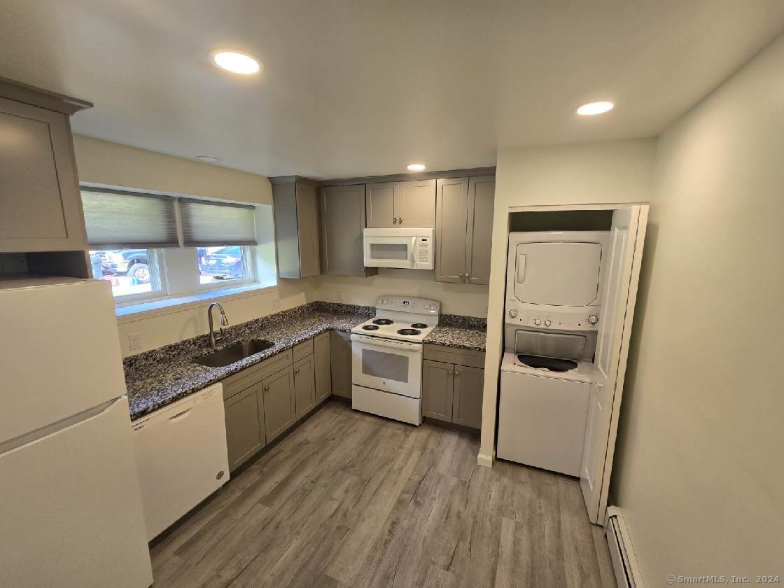 a kitchen with a sink a stove top oven and refrigerator