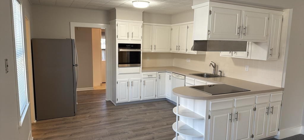 a kitchen with white cabinets and refrigerator