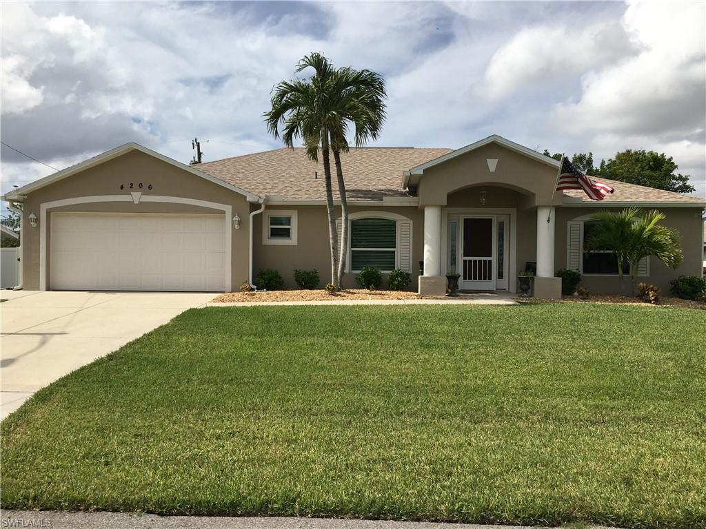 Single story home with a garage and a front lawn