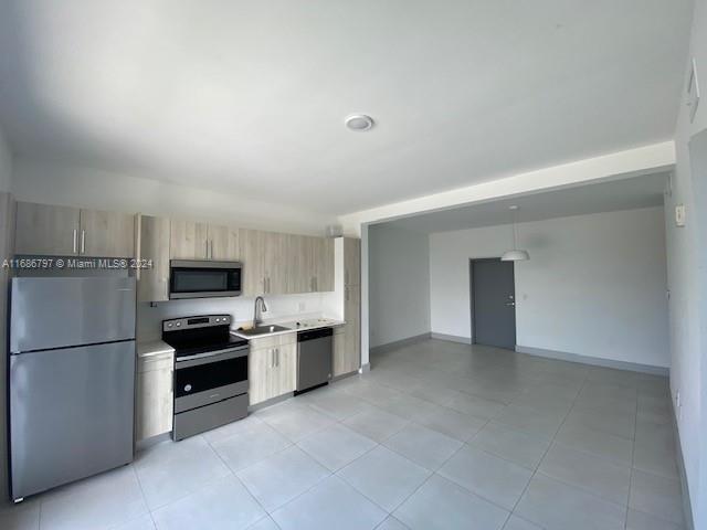 a view of kitchen with refrigerator stove microwave and cabinets