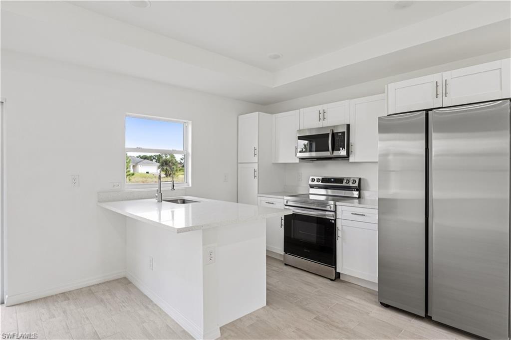 a kitchen with kitchen island granite countertop a sink stove and refrigerator