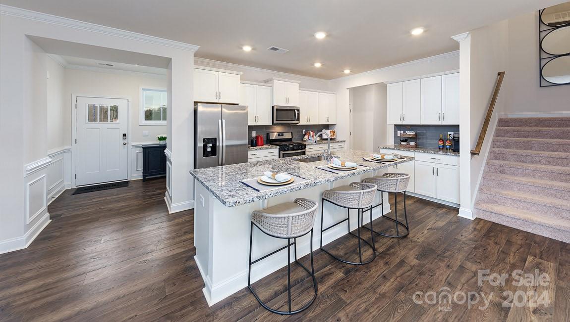 a open kitchen with stainless steel appliances granite countertop a stove refrigerator and cabinets