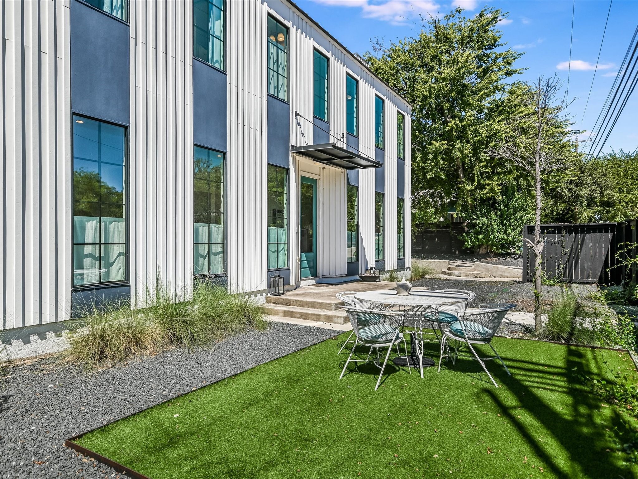 a view of backyard of house with outdoor seating and green space