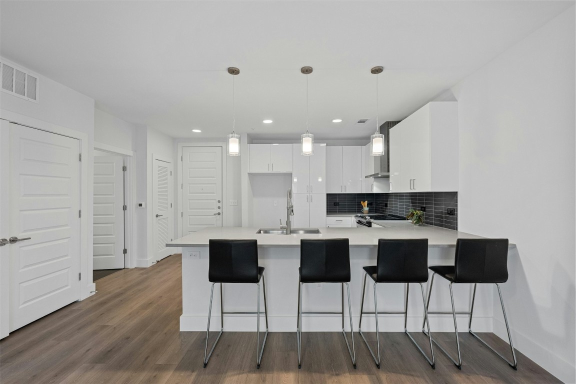 a kitchen with a dining table chairs and white cabinets