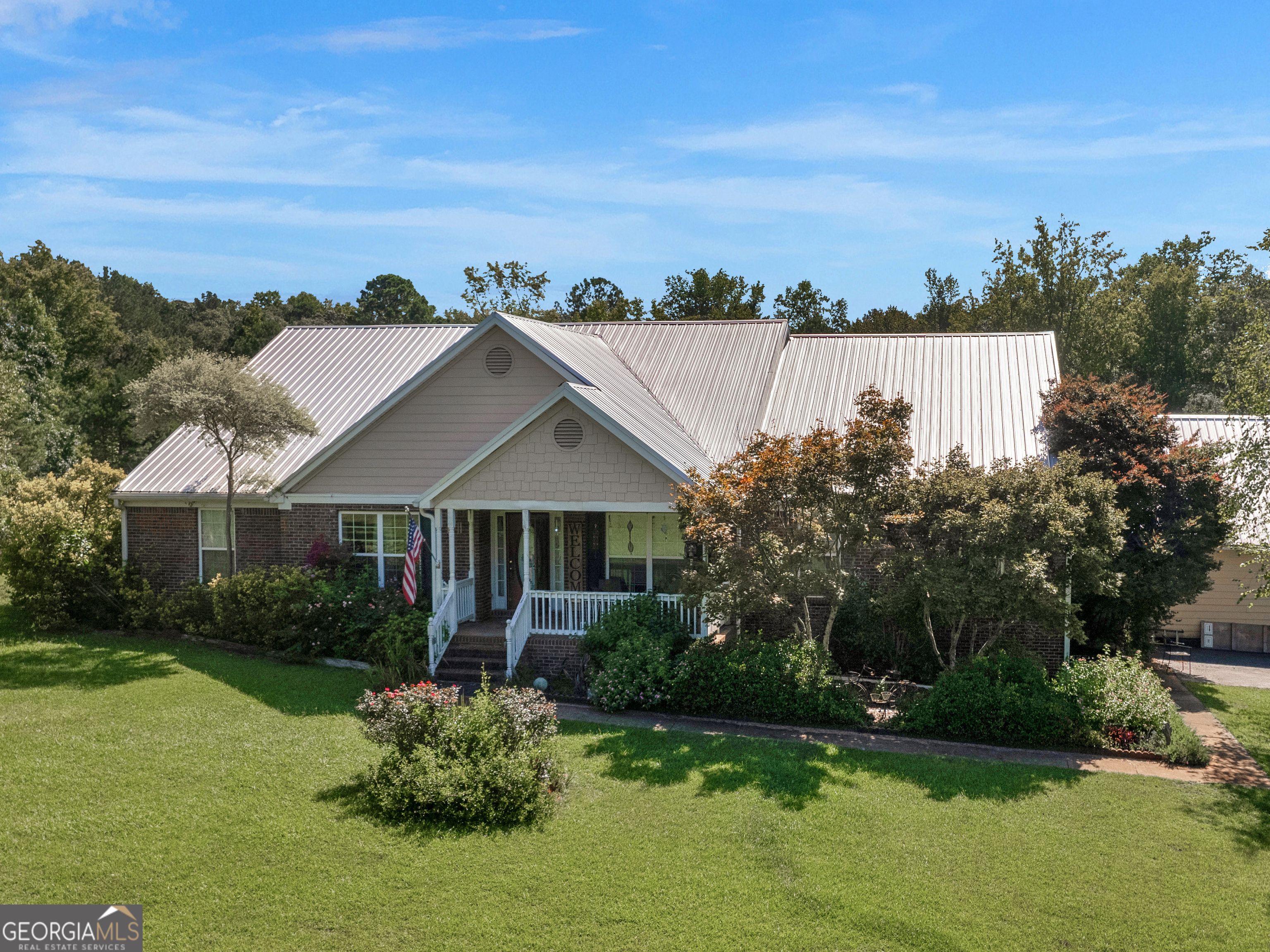 a front view of a house with a yard and lake view