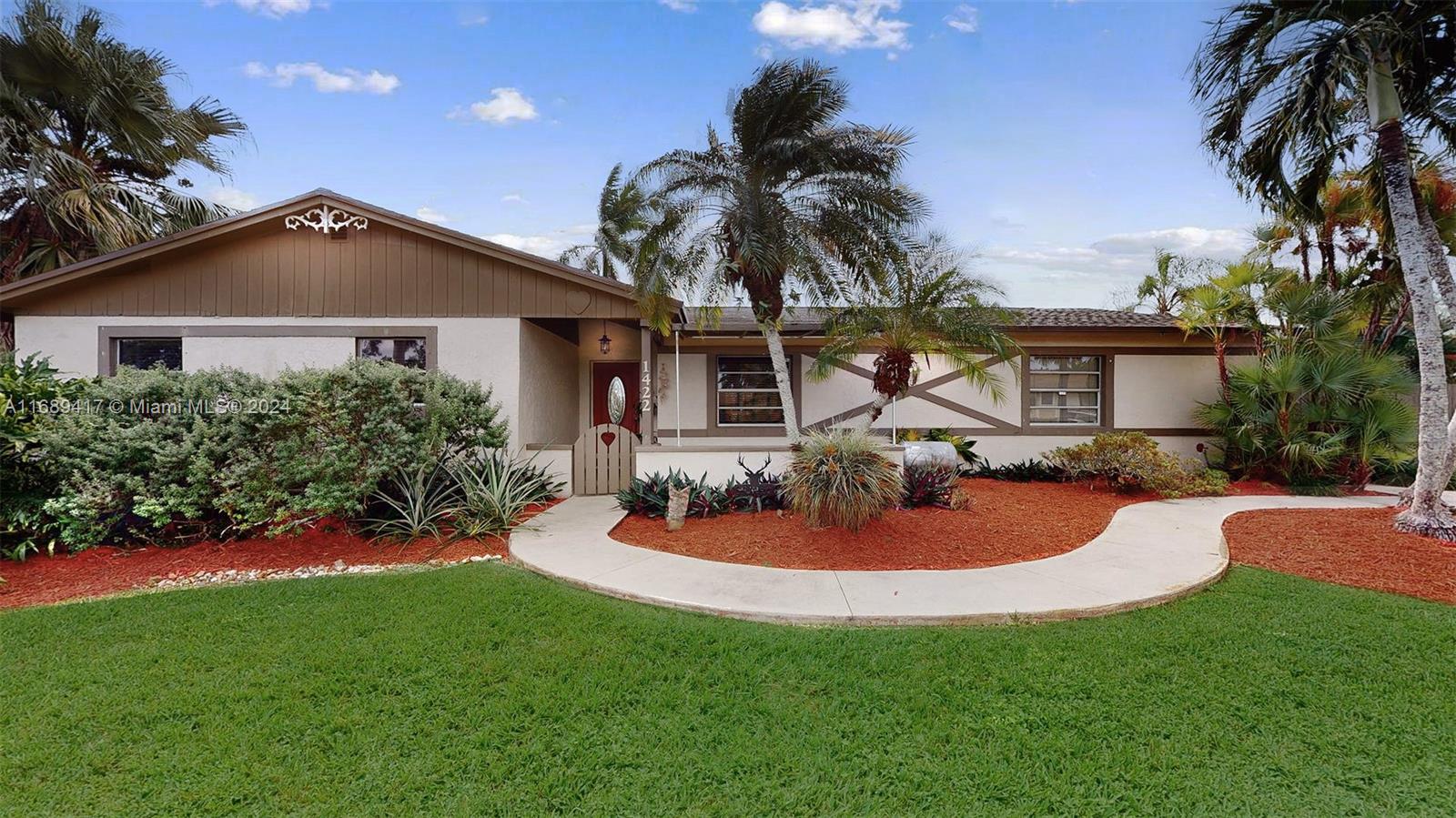 a view of a house with a backyard and a tree