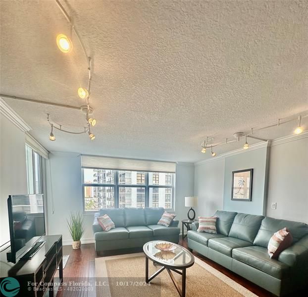 a living room with furniture a flat screen tv and a window