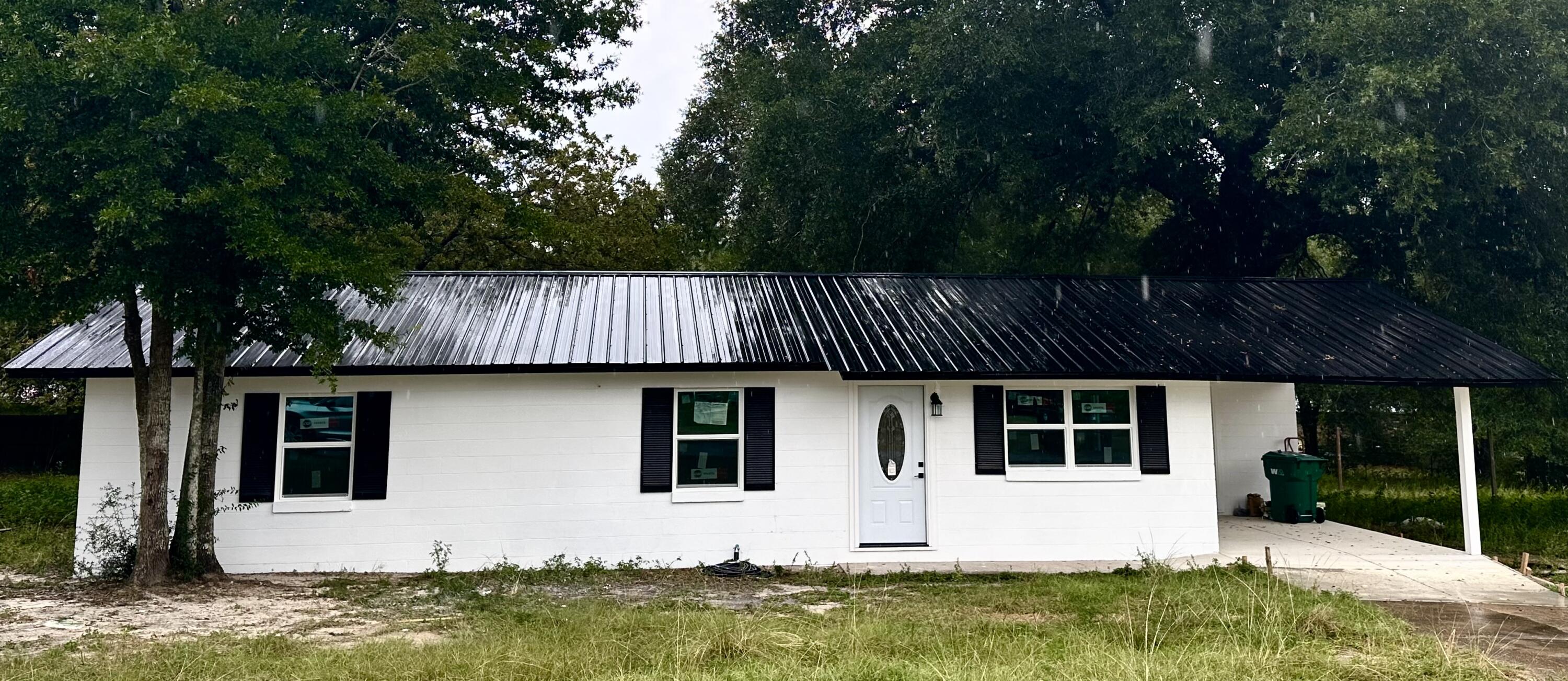 a front view of house with yard barbeque oven and outdoor seating