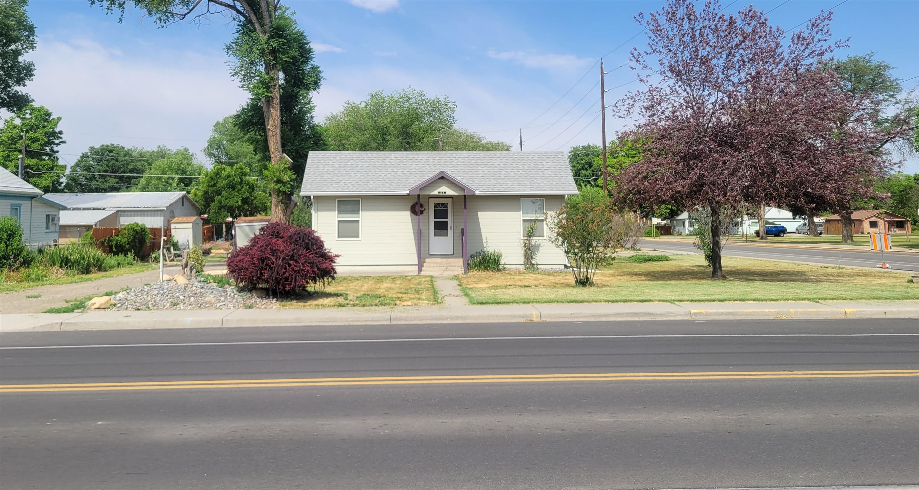 a view of a house with a yard and palm trees