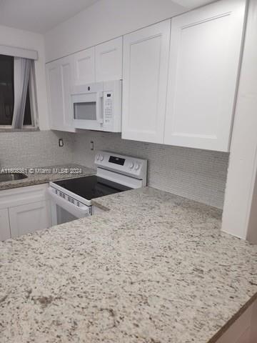 a kitchen with a sink cabinets and a stove