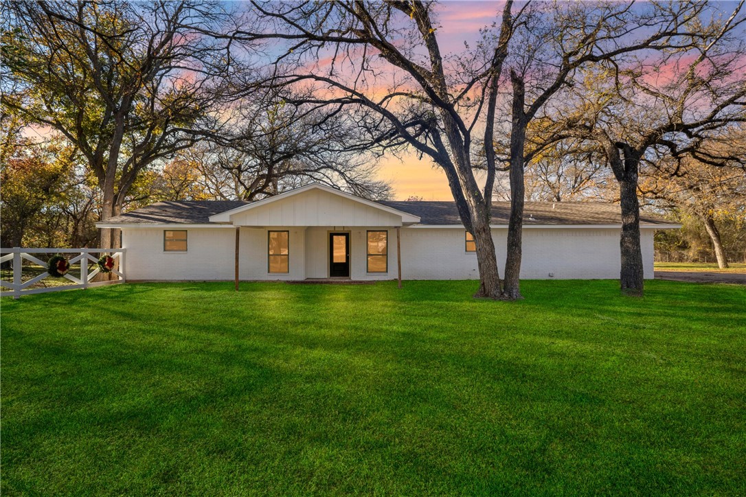 a view of a house with yard and tree s