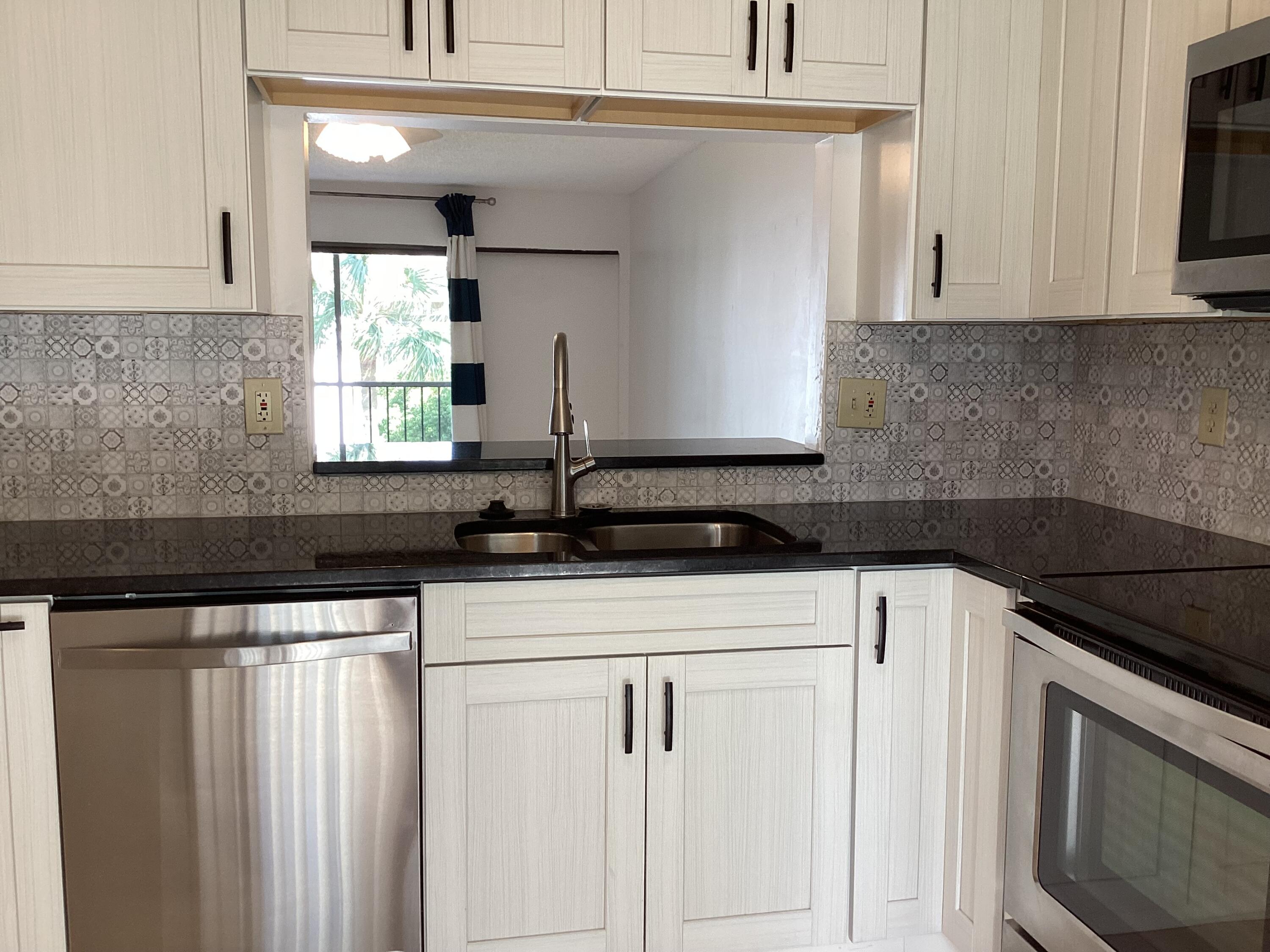 a kitchen with granite countertop white cabinets and white appliances